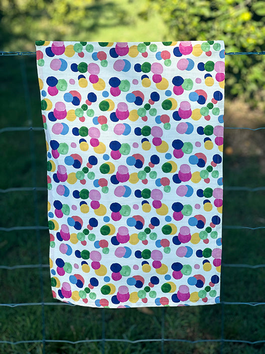 Bec Fing Designs Confetti Tea Towel hanging on fence. Bright colourful spots.